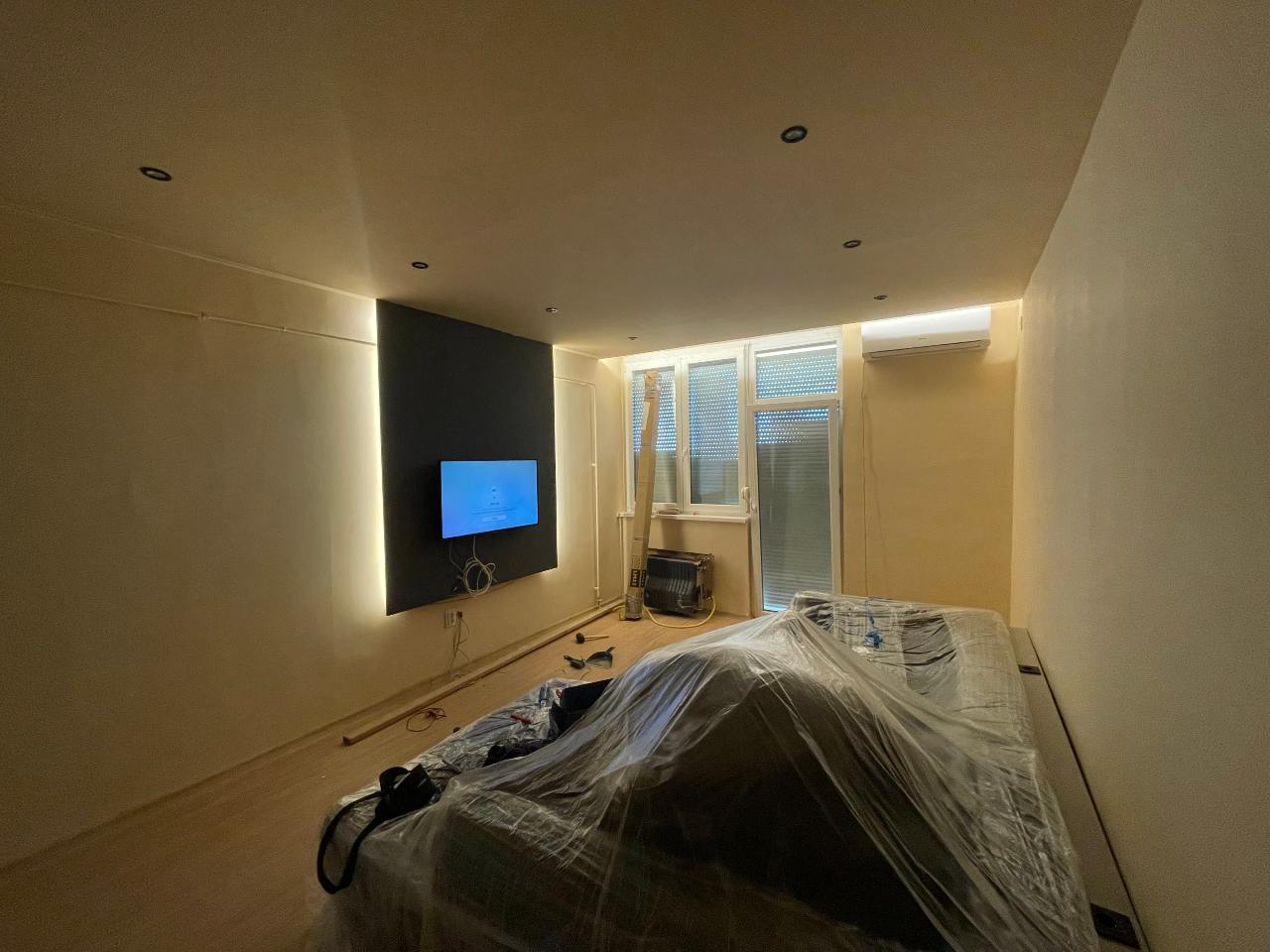 Épített gipszkarton TV fal meleg fehér rejtett LED világítással építés közben